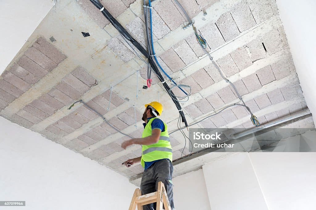 electrician fitting air conditioning to office interior